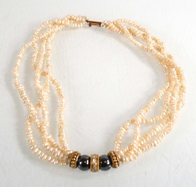 Lot 684 - A four strand pearl necklace with central...