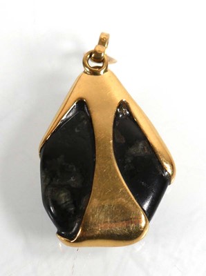 Lot 695 - A yellow metal pendant inset black...