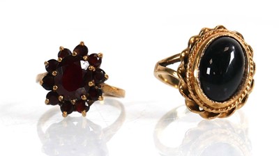 Lot 699 - A 9ct yellow gold cluster ring set garnet,...