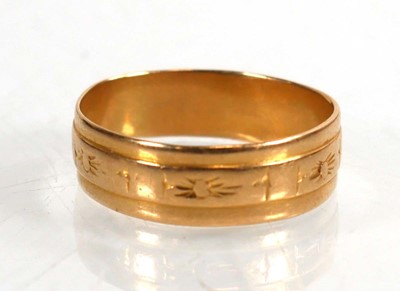 Lot 743 - An 18ct yellow gold wedding band with sunburst...