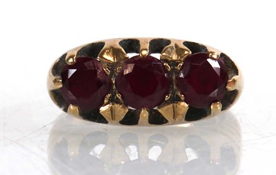 Lot 765 - A 9ct yellow gold ring set three garnets in a...