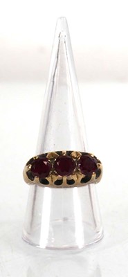 Lot 765 - A 9ct yellow gold ring set three garnets in a...