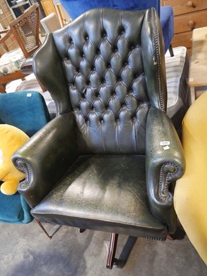 Lot 1584 - Green leather swivel easy chair upholstered in...