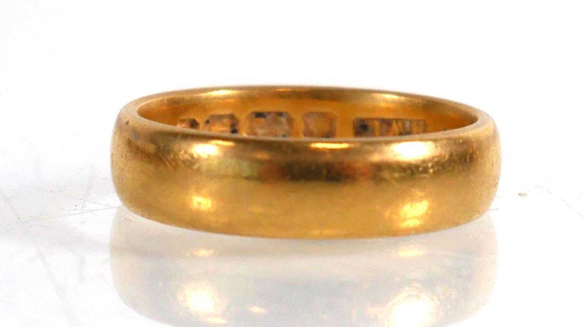 Lot 834 - An Edwardian 22ct yellow gold wedding band,...