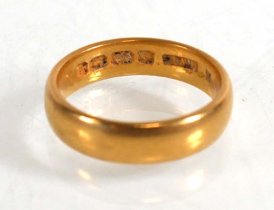 Lot 834 - An Edwardian 22ct yellow gold wedding band,...