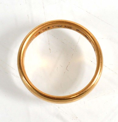 Lot 834 - An Edwardian 22ct yellow gold wedding band,...