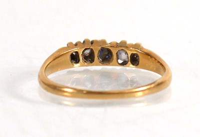 Lot 837 - An 18ct yellow gold ring set sapphire and four...