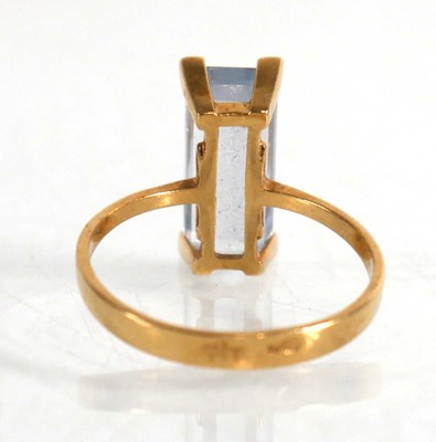 Lot 839 - A yellow metal ring set baguette cut pale blue...