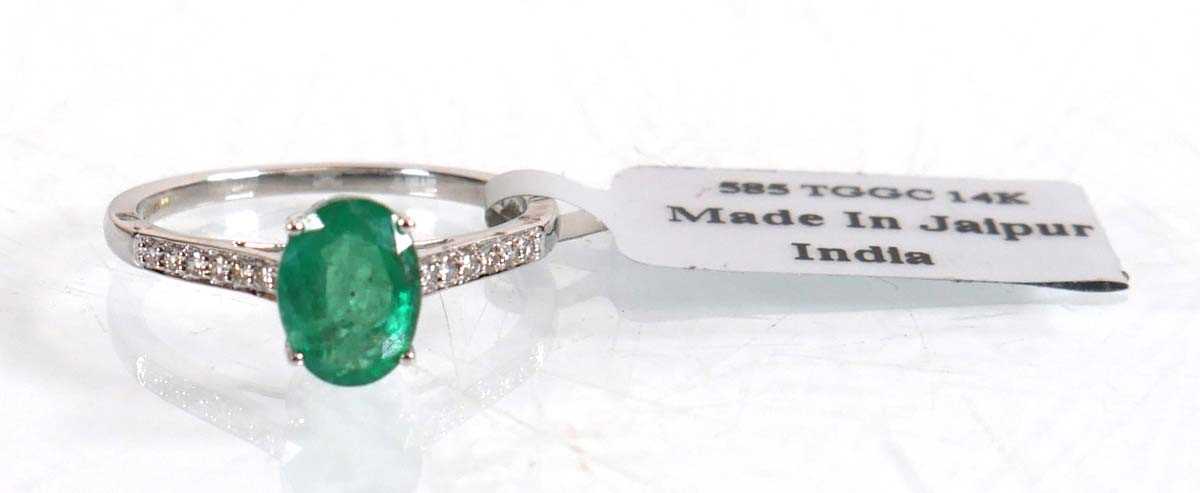 Lot 847 - An 18ct white gold ring set oval emerald in a...