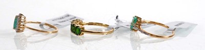 Lot 861 - Three 9ct yellow gold rings, each set emeralds...