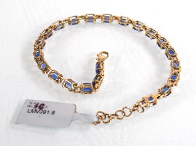 Lot 867 - A 9ct yellow gold bracelet set twenty-two oval...