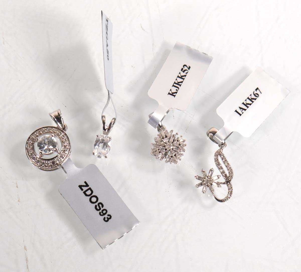 Lot 874 - Four 9ct white gold pendants, each set small...