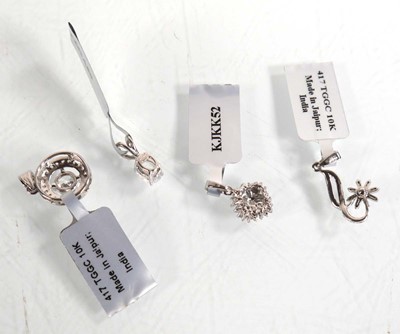 Lot 874 - Four 9ct white gold pendants, each set small...