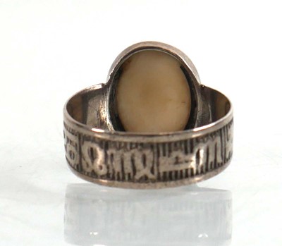 Lot 908 - A silver cameo ring, the band decorated with...