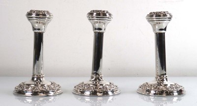 Lot 214 - Three early 20th century silver candlestick of...