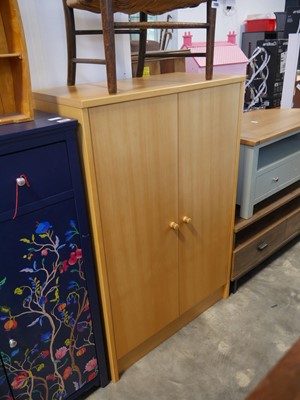 Lot 1106 - Beech effect double door storage cupboard