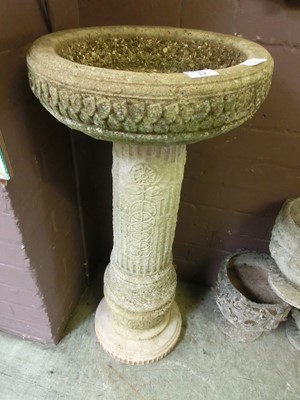 Lot 12 - A composite stone bird bath on fluted and...