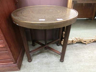 Lot 60 - An eastern brass topped table on collapsible...