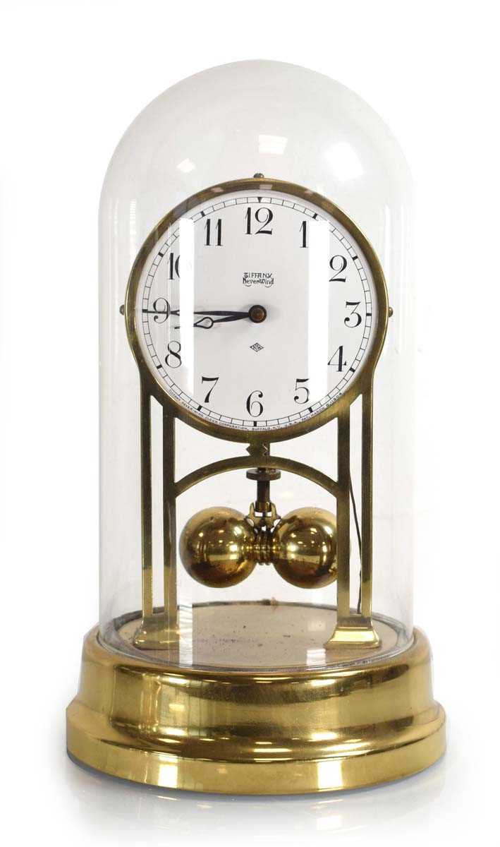 Lot 56 - An American brass anniversary clock under a...