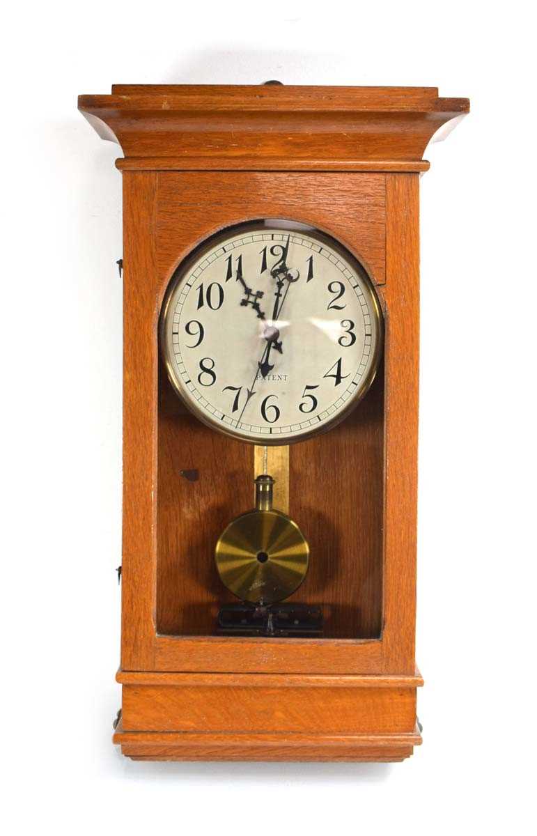 Lot 69 - An early 20th century electric wall clock, the...