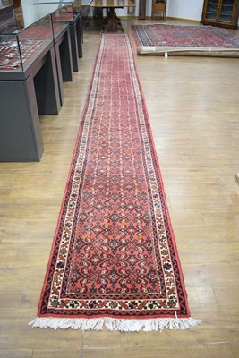 Lot 29 - A 20th century red ground runner, 780 x 77 cm