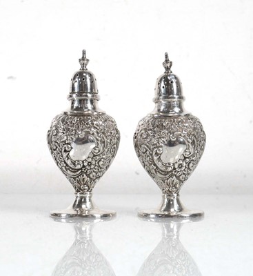 Lot 376 - A pair of Edwardian silver peppers of urn...