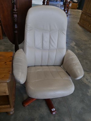 Lot 1021 - Beige leather upholstered swivel easy chair on...
