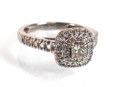 Lot 733 - An 18ct white gold halo ring set princess and...