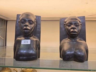Lot 315 - A pair of ebonised carved African bookends, in...