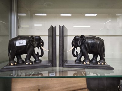 Lot 347 - A pair of ebonised bookends in the form of...