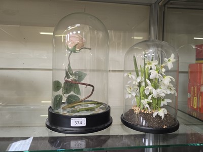 Lot 374 - Two glass domes on bases with artificial flowers