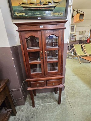 Lot 64 - An eastern hardwood glazed cabinet on stand...