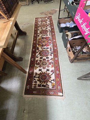 Lot 106 - A red ground woollen runner
