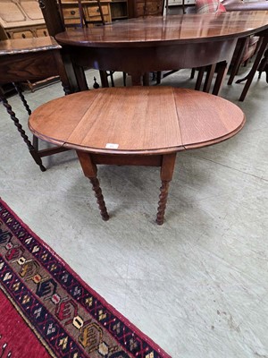 Lot 85 - A low level oak drop leaf table with barley...