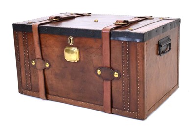 Lot 9 - A leather travel trunk with strap closure,...