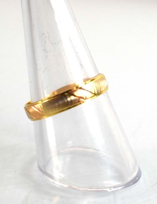 Lot 506 - A tri-colour metal wedding band with engraved...