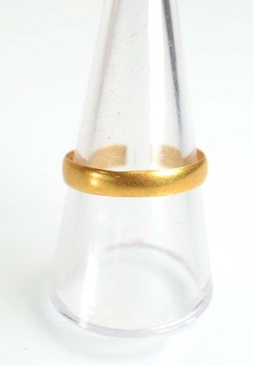 Lot 510 - A 22ct yellow gold wedding band, London 1934,...