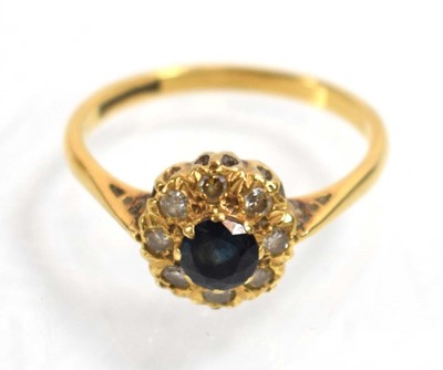 Lot 512 - An 18ct yellow gold cluster ring set sapphire...