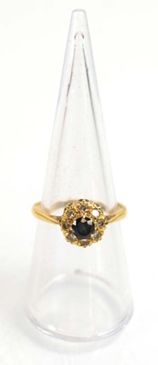 Lot 512 - An 18ct yellow gold cluster ring set sapphire...