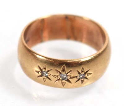 Lot 518 - A 9ct yellow gold band ring set three small...