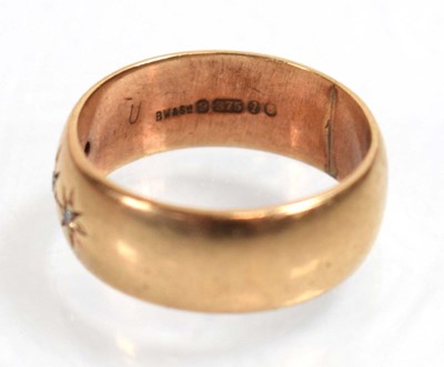 Lot 518 - A 9ct yellow gold band ring set three small...