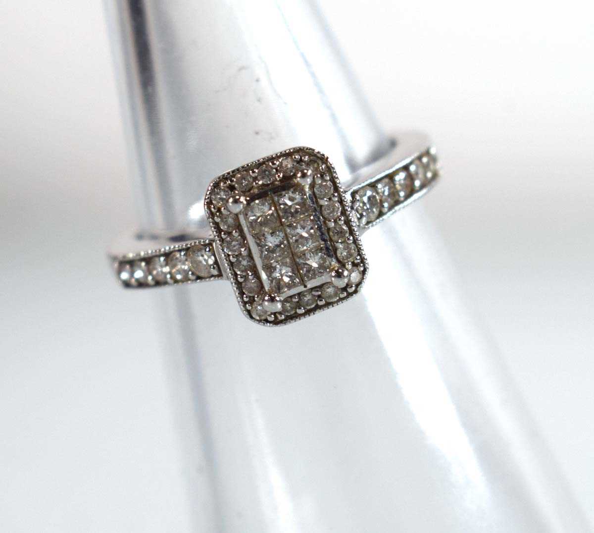 Lot 545 - A 9ct white gold halo type ring set small...