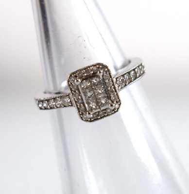 Lot 545 - A 9ct white gold halo type ring set small...