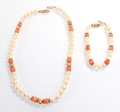 Lot 555 - A single strand cultured pearl and coral bead...