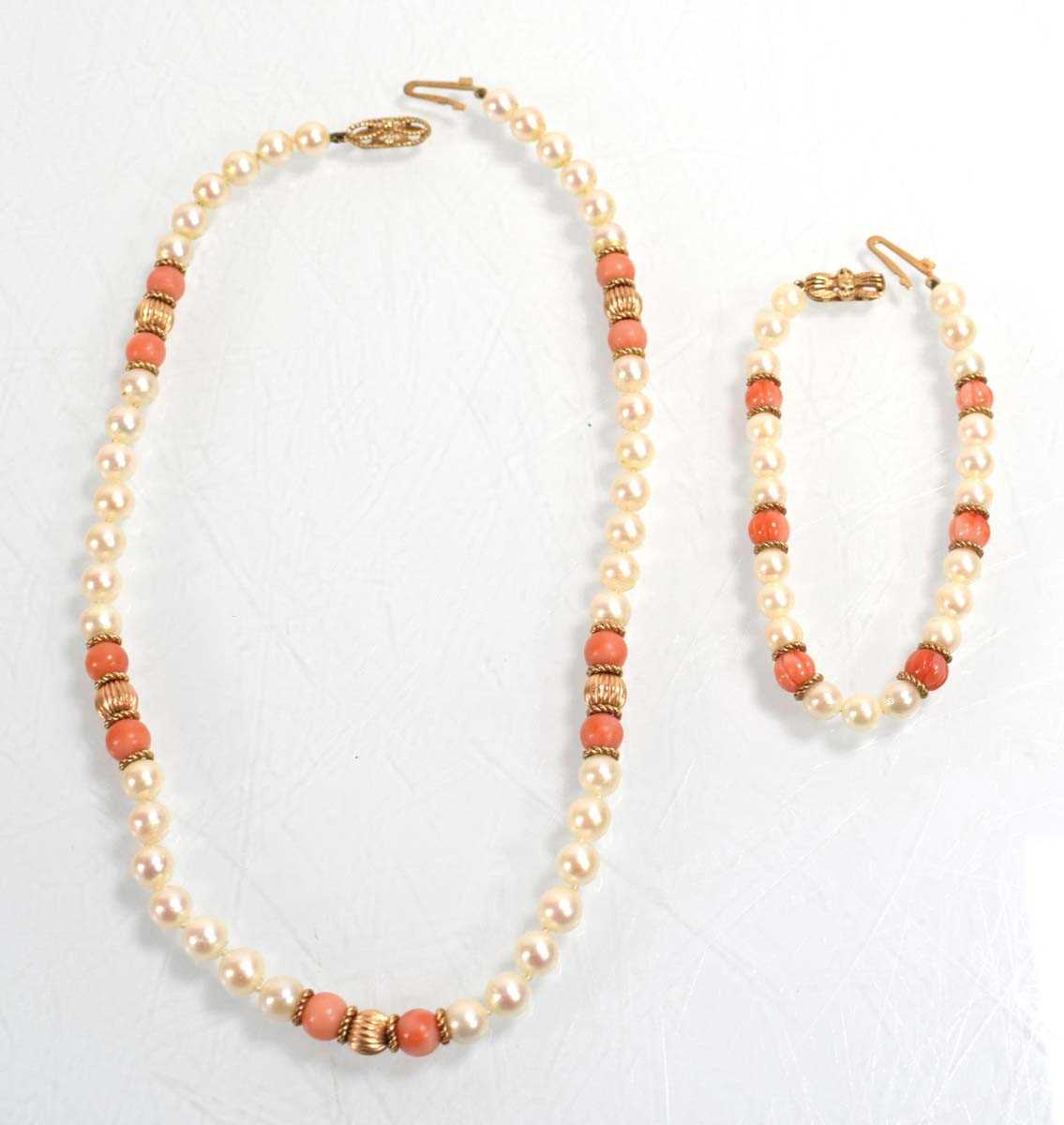 Lot 555 - A single strand cultured pearl and coral bead...