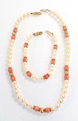Lot 555 - A single strand cultured pearl and coral bead...
