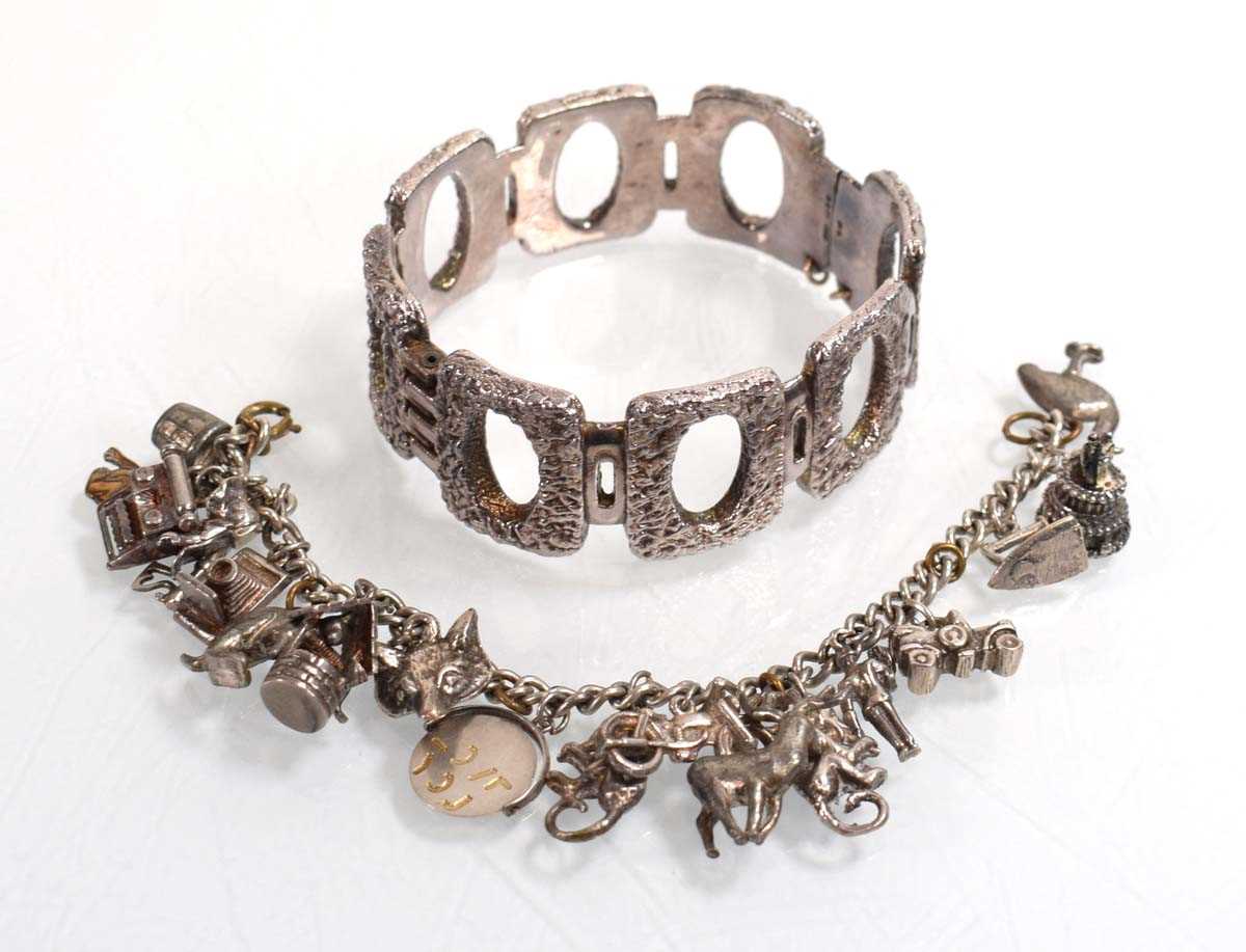 Lot 556 - A silver curblink bracelet suspending a...