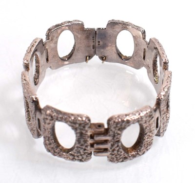 Lot 556 - A silver curblink bracelet suspending a...
