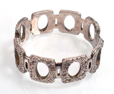 Lot 556 - A silver curblink bracelet suspending a...