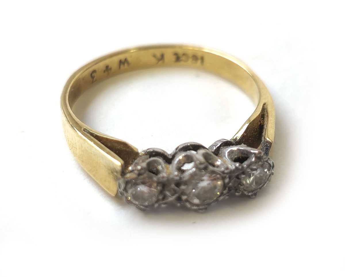 Lot 405 - A yellow metal and diamond trilogy ring marked...